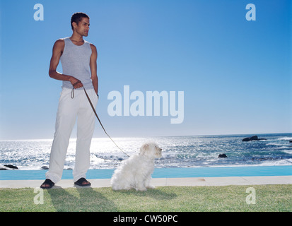 Young man holding a dog on a leash Stock Photo
