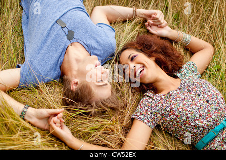 Happy couple laying together in grass field Stock Photo