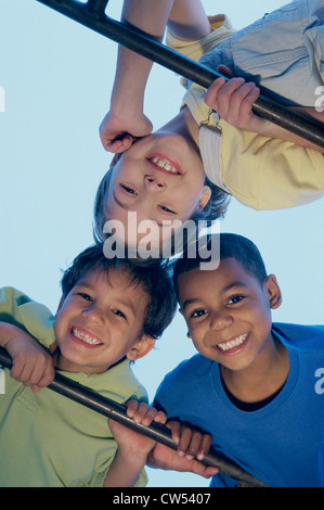 Portrait of two boys and a girl playing on monkey bars Stock Photo