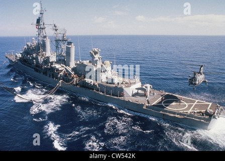 Military helicopter landing on a military ship, USS William V. Pratt while it is being refueled, Red Sea Stock Photo