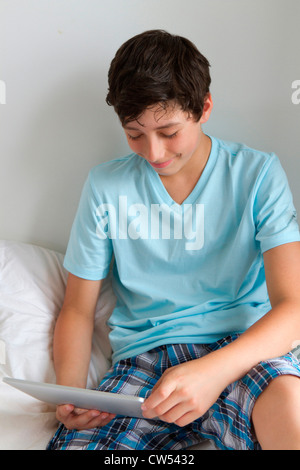 Boy in bed using tablet pc Stock Photo