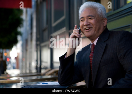 Businessman talking on a mobile phone and smiling Stock Photo