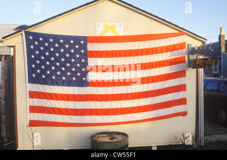 American Flag and Yellow Ribbon Hung on Shed Stock Photo