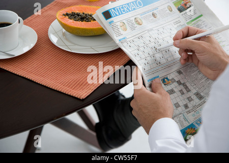 High angle view of a man solving Sudoku puzzle Stock Photo