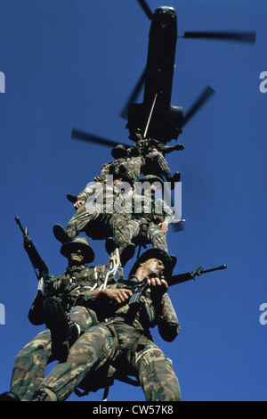 Low angle view of soldiers being airlifted by a military helicopter Stock Photo