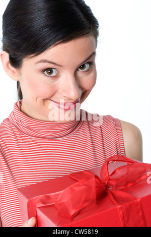 Portrait of a young woman holding a gift and smiling Stock Photo