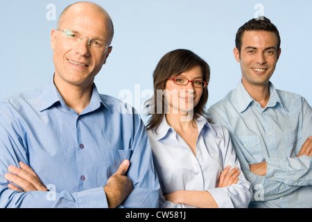 Three business executives standing with their arms crossed and smiling Stock Photo