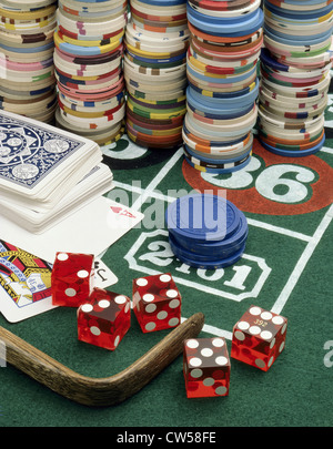 Close-up of stacks of gambling chips with playing cards and dice on a roulette table Stock Photo