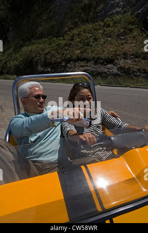 Mature woman driving a tourist car with a mature man sitting beside her Stock Photo
