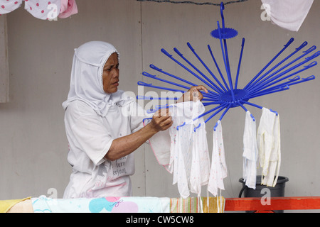 A woman hangs laundry out to dry on a Waeschespinne Stock Photo