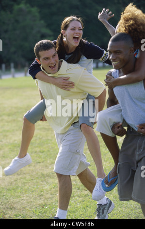 Two young women riding piggyback on two young men Stock Photo