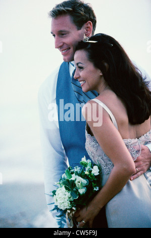 Young man standing with his arm around a young woman and smiling Stock Photo