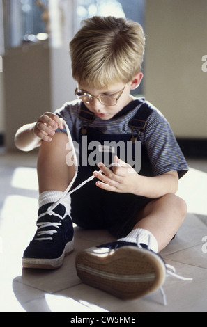Close-up of a boy tying his shoelaces Stock Photo