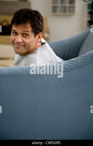 Side profile of a mature man sitting on a couch and smiling Stock Photo
