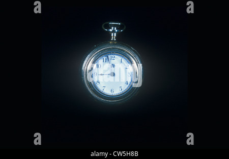 A pocketwatch against a black background Stock Photo