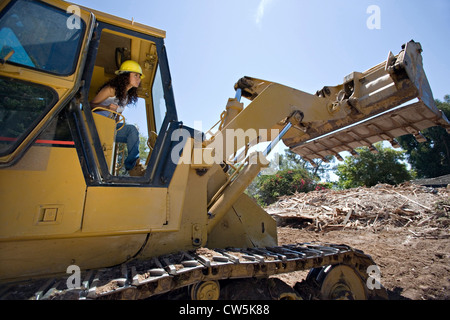 Female construction worker operating a bulldozer at a construction site Stock Photo