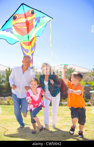 Family flying a kite in a park Stock Photo