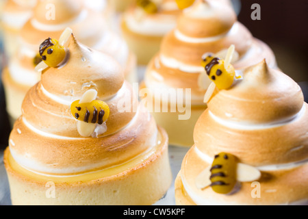 Lemon meringue tarts with marzipan bees Stock Photo