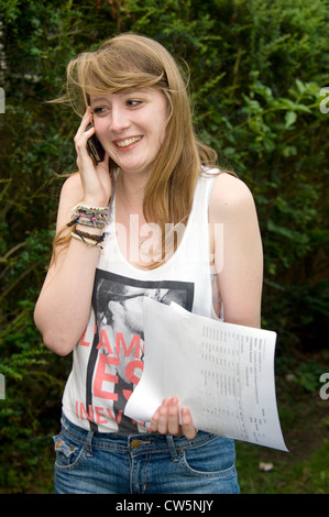 A happy and pleased student phoning home with her successful GCSE exam results at a School in London, England, UK.