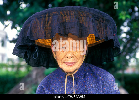 China New Territories elderly woman in large hat smoking pipe placing  vegetables in box Stock Photo - Alamy