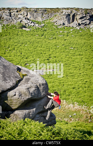 Tom Randall rock climbs a crack at Burbage in Sheffield near Stanage on the Peak District National Park Derbyshire, England