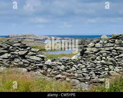 Stone fence wall with an opening framing rocks, shoreline and the north sea near Stavanger Norway Stock Photo