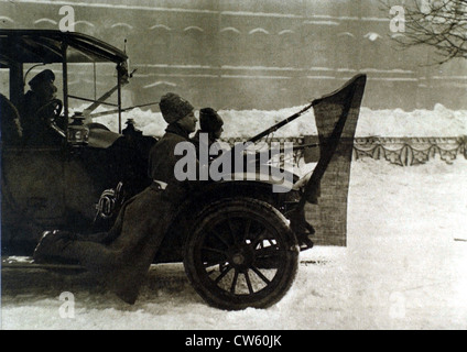Russian Revolution 1917. In Petrograd soldiers riding on running board automobile with red flags attached to their bayonets Stock Photo