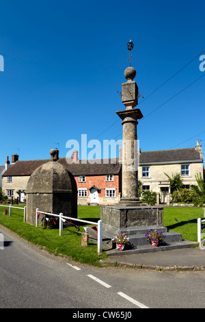 The Blind House and Market Cross are set on the village green in the High Street, of Steeple Ashton, Wiltshire, UK. Stock Photo