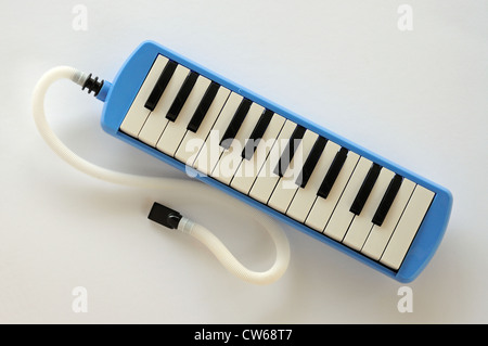 Blue and white Pianica blow-organ with finger pressing middle C Stock ...
