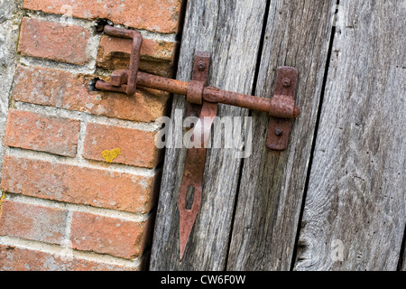 Rusty lock on a doorway to a French outbuilding. Stock Photo