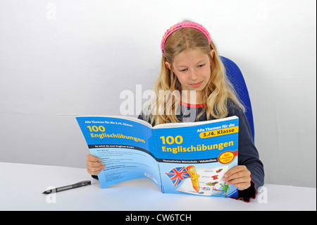 schoolgirl reading happily in a English book Stock Photo