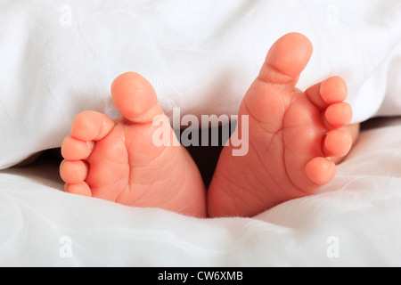 a baby's feet sticking out from under the blanket Stock Photo