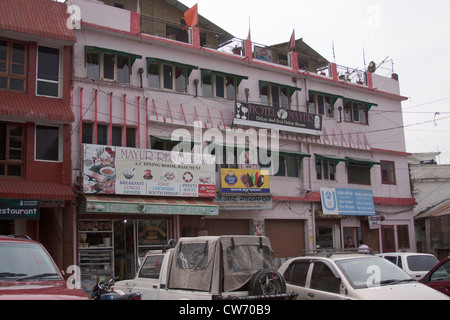 Mayur restaurant in the market in Lansdowne in North India with vehicles and cars in front. A small market with few shops in it. Stock Photo