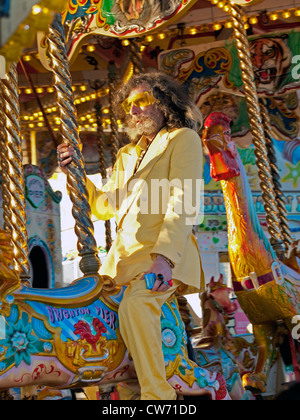 A man in a yellow suit amuses himself on the pier at Brighton. Stock Photo