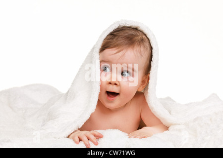 small astonished child baby wrapped in blanket Stock Photo