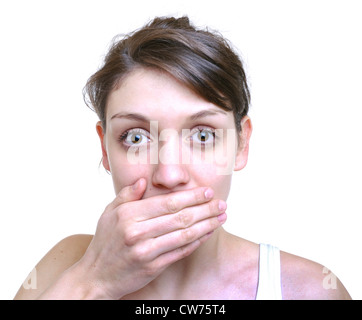 Young darkhaired woman holds her hand on her mouth Stock Photo