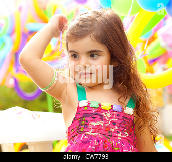 Closeup portrait of playful sweet small female child, 3-year old girl birthday party, adorable pretty kid with hand up Stock Photo