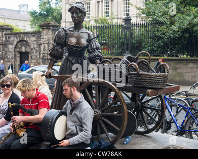 Dublin Ireland - Buskers at bronze statue of Molly Malone on Grafton Street, beside Trinity College, by sculptor Jeanne Rynhart Stock Photo