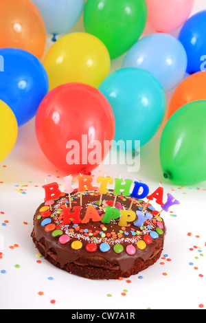 happy birthday chocolate cake with candles and balloons Stock Photo