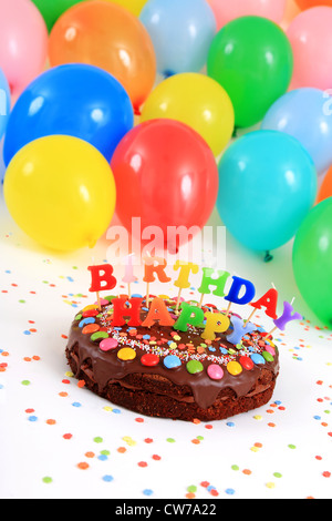 happy birthday chocolate cake with candles and balloons Stock Photo