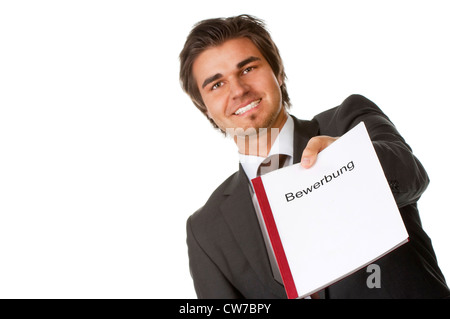 friendly young man handing over his application, Germany Stock Photo