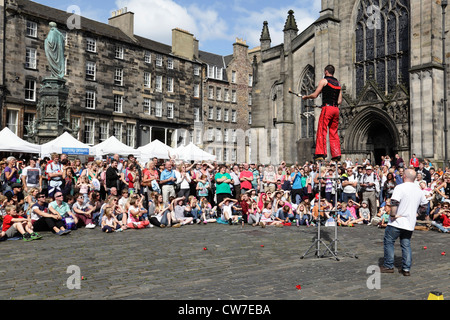 Spectators watching a street performance at the Edinburgh Festival Fringe, West Parliament Square, Scotland, UK Stock Photo