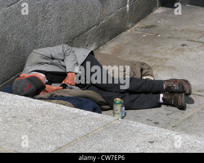 Homeless person with beer can lying on a sleeping bag on the city hall market in Hamburg, Germany, Hamburg Stock Photo