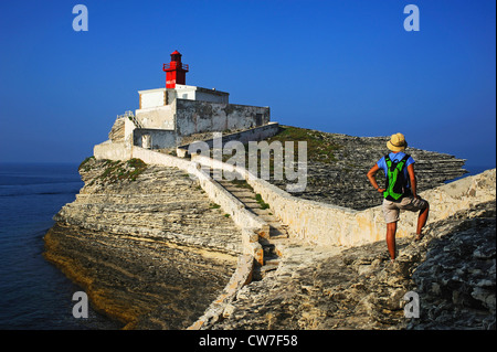 female hiker at lighthouse of Madonella near Bonifacio, France, Corsica Stock Photo