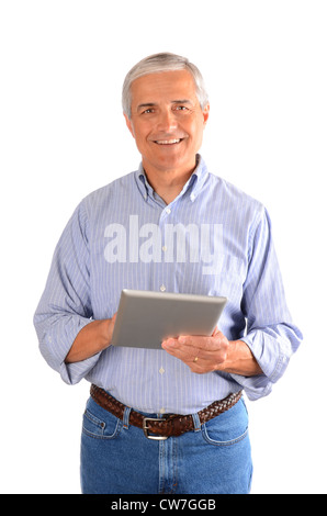 A casually dressed businessman holding a tablet computer, and smiling at viewer. Vertical composition over a white background. Stock Photo