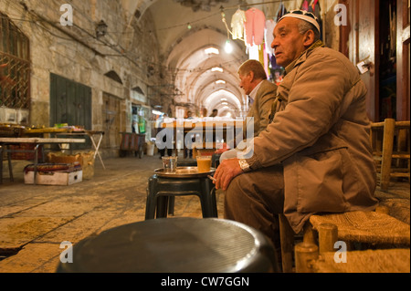 elderly man sitting in the Old City and drinking coffee, Israel, Jerusalem Stock Photo