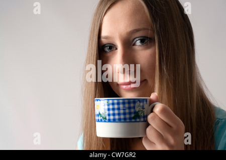 long haired woman close up portrait with a cup of tea in hand Stock Photo