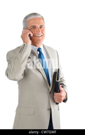 Middle aged businessman talking on his cell phone and carrying a binder. Man is smiling. Stock Photo