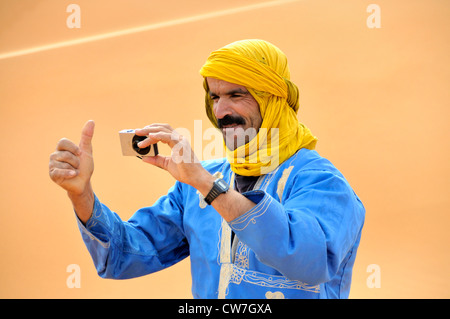 berber taking photos with compact digital camera, Morocco, Erg Chebbi, Sahara Stock Photo