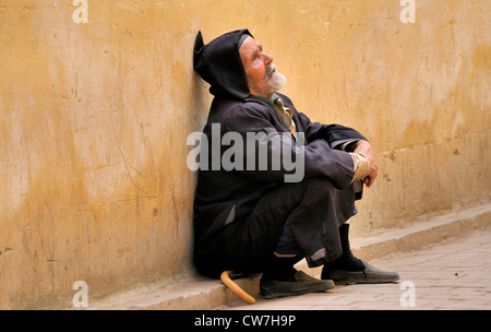 blind beggar sitting at house wall, Morocco, Fes Stock Photo